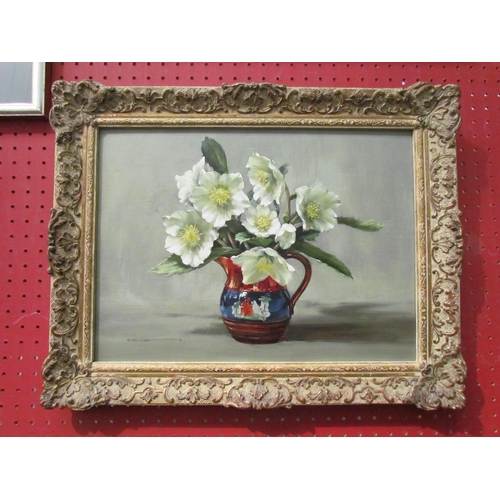 1112 - E. BRIDGE: An oil on board still-life of flowers in a jug, signed lower left, framed, 28cm x 39cm im... 