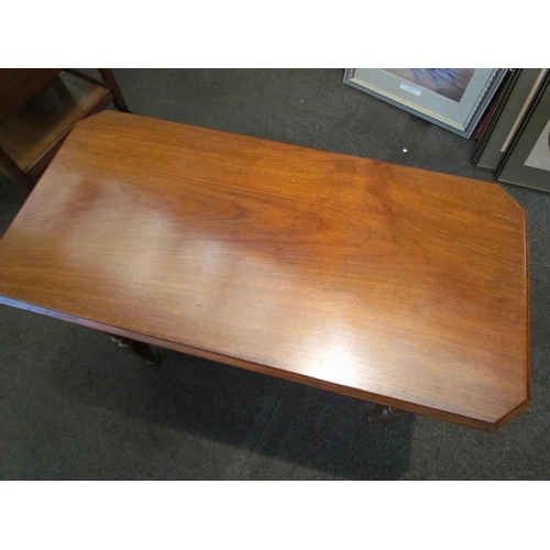 1123 - An Edwardian walnut table, canted corners, ring-turned legs joined by a spindle stretcher, 68cm tall... 