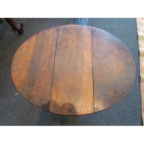 1130 - A Georgian mahogany drop-leaf oval occasional table with inverted cup legs, 48cm tall, 61cm long