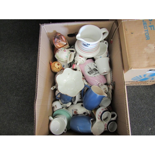 1440 - A box of mixed ceramics including pink lustre tourist jug, crested wares, teapot etc