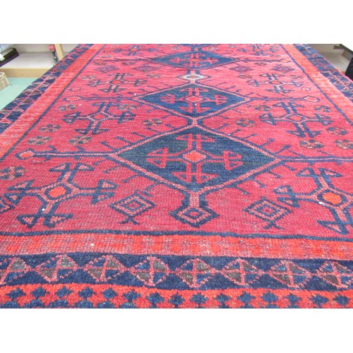 4004 - An Eastern red ground wool rug, four central navy medallions, flanked by multiple borders, 146cm x 2... 
