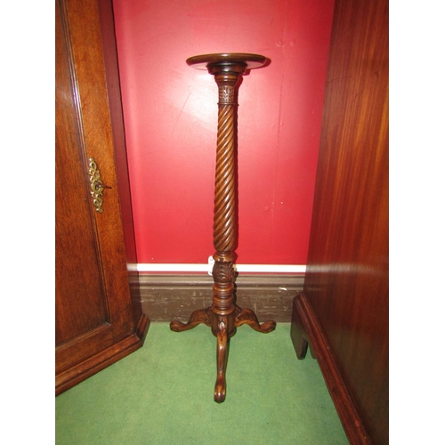 4051 - A George II style walnut candle stand, the dished circular top over a tapering spiral, turned and ca... 