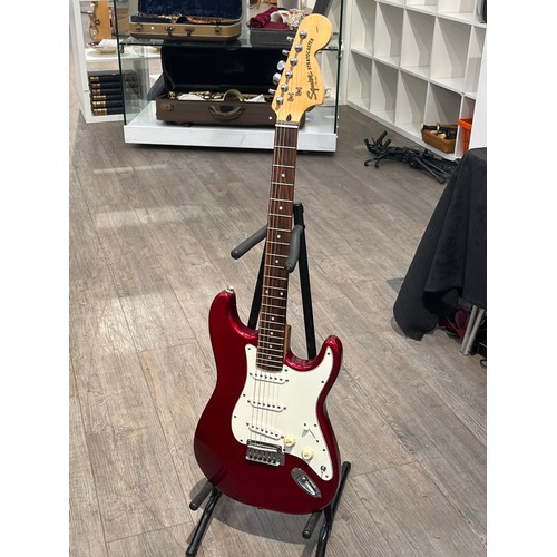 7081 - A Fender Squier strat in red, serial number ICO60625142