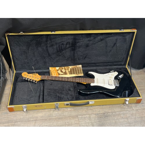 7088 - An Encore Stratocaster style electric guitar with black body, tweed hard case