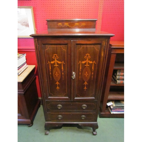 4087 - An Edwardian mahogany cabinet, the twin doors inlaid with marquetry swags, over two long drawers, ca... 