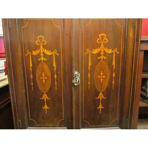 4087 - An Edwardian mahogany cabinet, the twin doors inlaid with marquetry swags, over two long drawers, ca... 