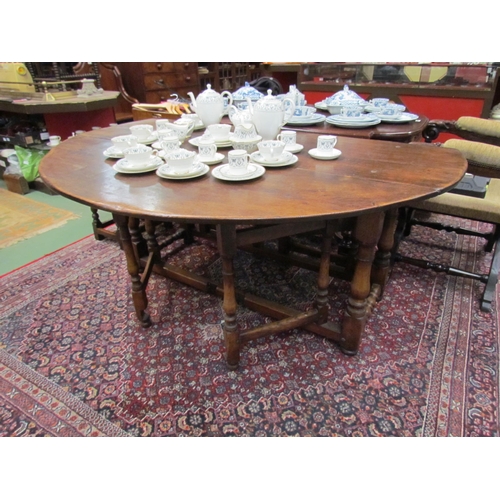 4103 - A 20th Century oak gate-leg dining table in the 17th Century style with single end drawer, turned su... 