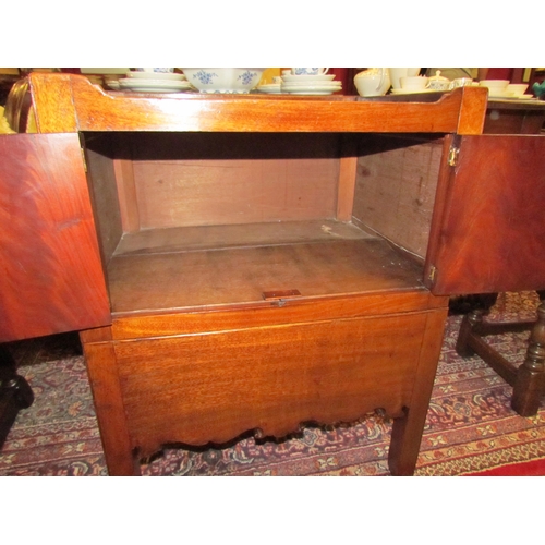 4109 - A George III mahogany nightstand with fret handle raised gallery over a two door cupboard and base d... 