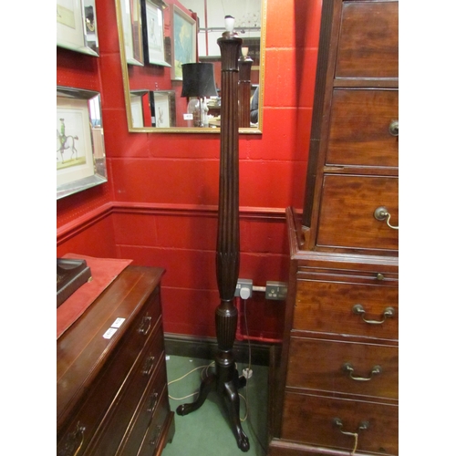 4121 - A carved mahogany standard lamp with turned and fluted column on ball in claw tripod base