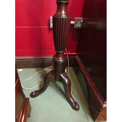 4121 - A carved mahogany standard lamp with turned and fluted column on ball in claw tripod base