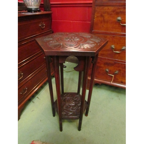 4124 - An Arts & Crafts two tier carved lamp table with Moorish design, the hexagonal top and shelf joined ... 