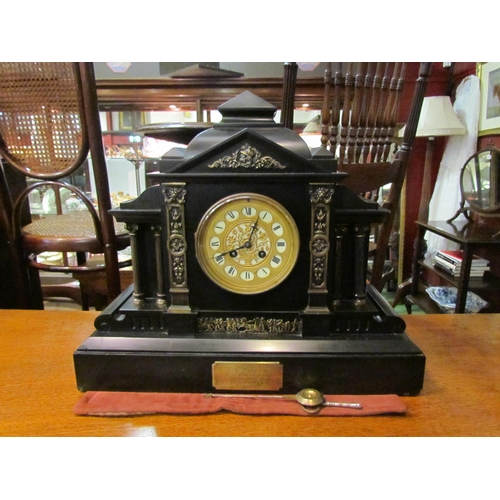 4200 - A Victorian slate mantel clock of architectural form, Roman numeral dial, bearing presentation plaqu... 