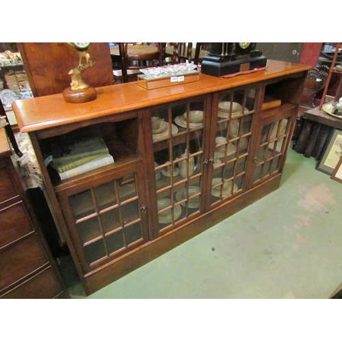 4206 - A 20th Century oak sideboard, four astragal glazed doors and two alcoves, on plinth base,  110cm tal... 