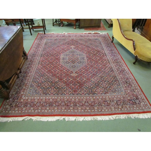 4394 - A large red ground rug with multiple boarders in navy and cream design,  310cm x 250cm