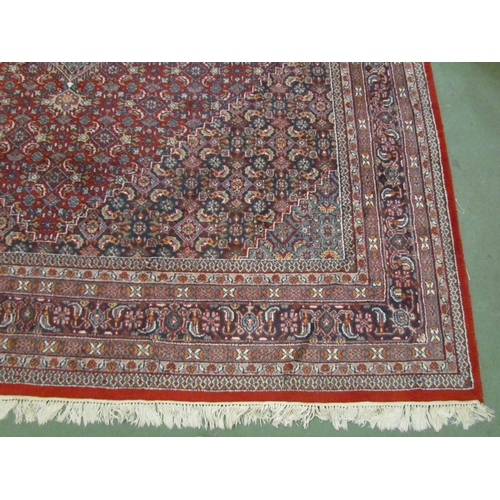 4394 - A large red ground rug with multiple boarders in navy and cream design,  310cm x 250cm