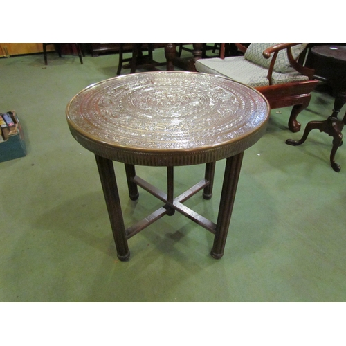 4215 - An Eastern brass top table, 59cm diameter, on campaign folding base