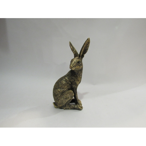 4209 - A resin bronze seated hare. 20cm tall.