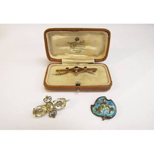 8299 - A gold bar brooch stamped 9ct, 2.5g, a silver enamelled brooch and a costume brooch with pale yellow... 