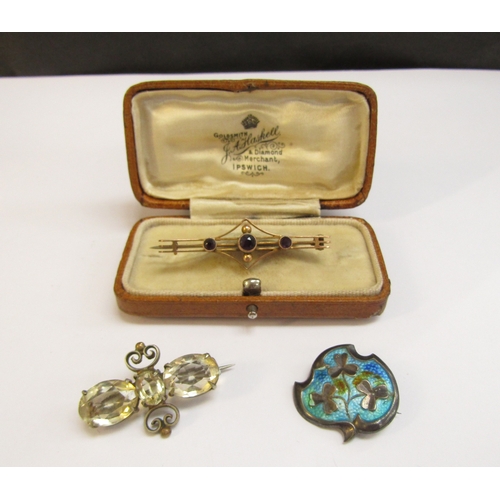 8299 - A gold bar brooch stamped 9ct, 2.5g, a silver enamelled brooch and a costume brooch with pale yellow... 