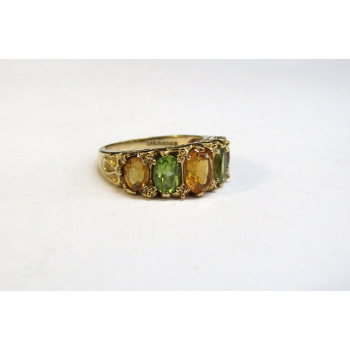 8295 - A 9ct gold ring set with alternate peridot and citrine in scroll mount. Size K/L, 3.7g