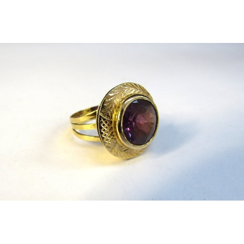 8308 - A gold ring set with a circular amethyst in a wide etched frame. Size L/M, 5g