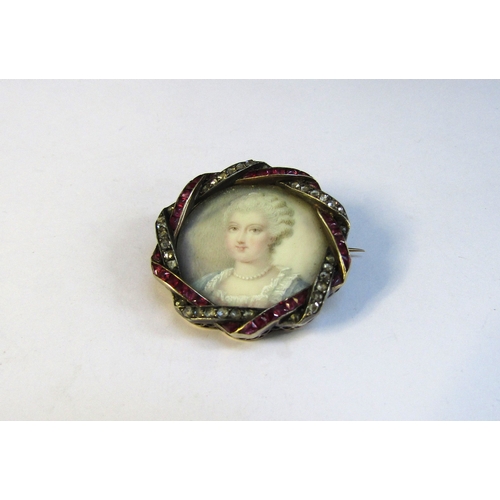 8312 - A 19th Century ruby and diamond framed miniature on ivory circular brooch depicting a female in blue... 