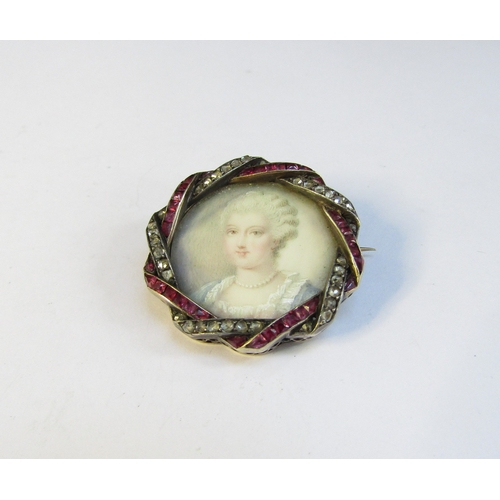 8312 - A 19th Century ruby and diamond framed miniature on ivory circular brooch depicting a female in blue... 