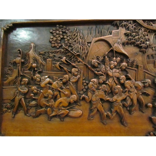 1032 - An early 20th Century Oriental carved panel depicting celebratory scenes, 45cm x 86cm   (R) £50