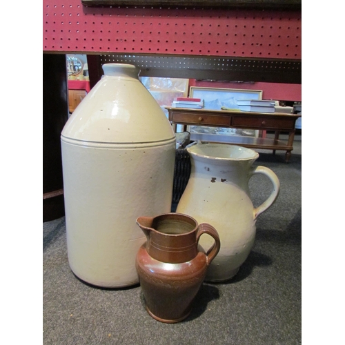 1135 - A large stoneware carboy together with large cream earthenware jug and a brown salt glazed stoneware... 