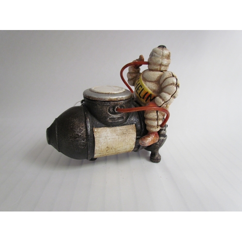 9261 - A cast reproduction Michelin Man sitting on a compressor