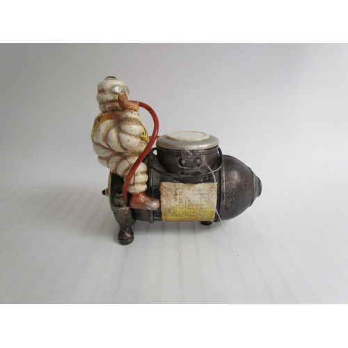 9261 - A cast reproduction Michelin Man sitting on a compressor