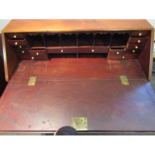 1021 - A George III mahogany bureau, the drop-flap with fitted interior over four graduating long drawers, ... 