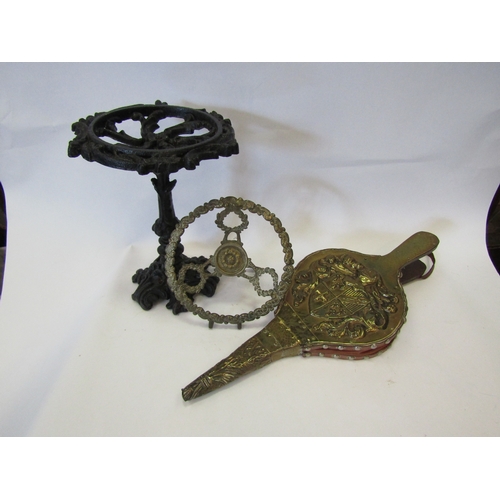 1062 - A black painted cast metal trivet with another and a pair of brass fire bellows (3)