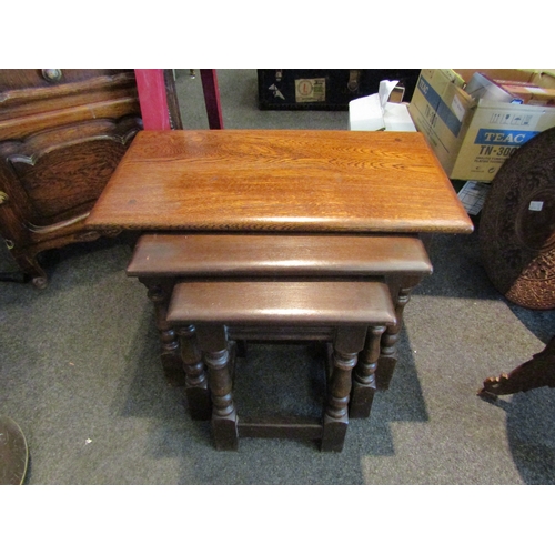 1066 - A nest of three Old Charm oak tables, with label, largest 45cm tall x 60cm wide x 33cm deep