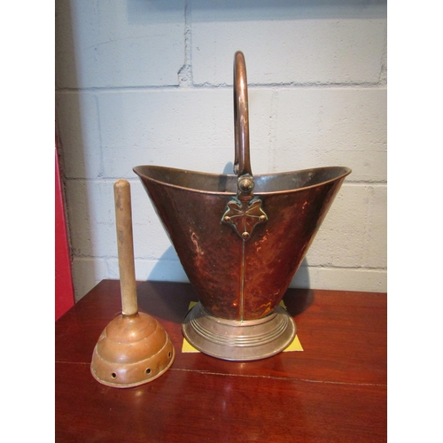 1077 - An Arts & Crafts copper coal scuttle, leaf design mounts, together with a copper posser (2)