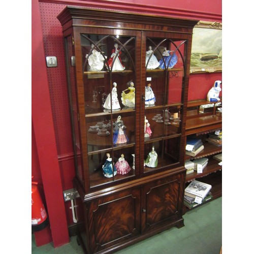 4033 - In the manner of Bevan & Funnell a George III style flame mahogany two door glazed bookcase over a t... 