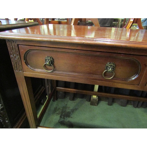 4054 - A Georgian mahogany serving table the two frieze drawers with brass lion-mask ring handles over carv... 