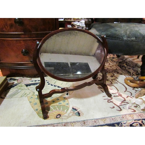 4063 - A mahogany dressing chest oval tilt mirror with blue cabochon decoration, 25cm x 34cm mirror size