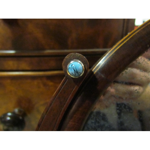 4063 - A mahogany dressing chest oval tilt mirror with blue cabochon decoration, 25cm x 34cm mirror size