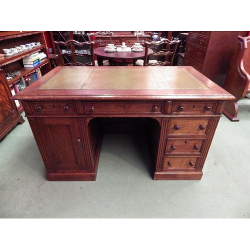 4116 - A circa 1900 panelled oak twin pedestal desk, the gilt tooled leather insert over six drawers and si... 