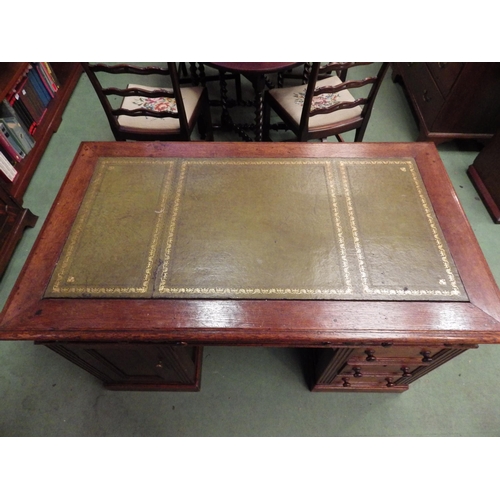 4116 - A circa 1900 panelled oak twin pedestal desk, the gilt tooled leather insert over six drawers and si... 