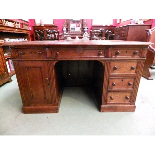 4116 - A circa 1900 panelled oak twin pedestal desk, the gilt tooled leather insert over six drawers and si... 