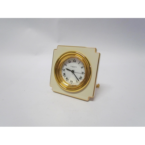 8091 - A Cartier alarm clock, cream and gilt brass, boxed with instructions. 7cm tall