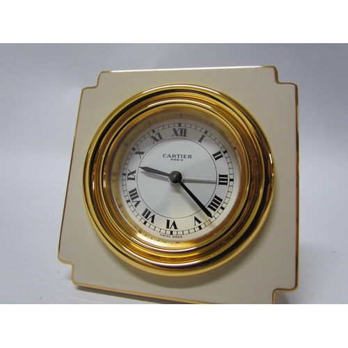 8091 - A Cartier alarm clock, cream and gilt brass, boxed with instructions. 7cm tall