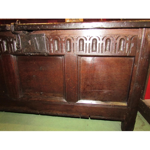 4004 - A 17th Century pegged oak three panel coffer with iron clasp front decoration on stile feet, 64cm ta... 