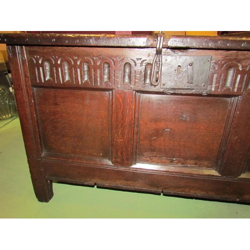 4004 - A 17th Century pegged oak three panel coffer with iron clasp front decoration on stile feet, 64cm ta... 