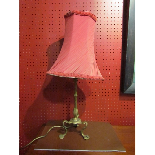 4046 - A brass table lamp with tri-footed stylised base, raspberry pleated chiffon vintage shade