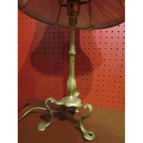 4046 - A brass table lamp with tri-footed stylised base, raspberry pleated chiffon vintage shade