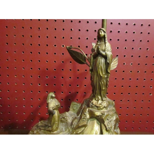 4047 - A French Lourdes gilt lamp base with religious theme, 27cm tall