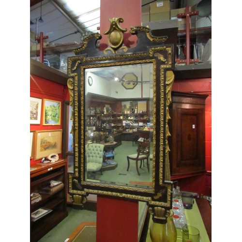 4105 - An ebonised and gilt ornate wall mirror with bevelled glass, a/f, 73cm x 41cm total